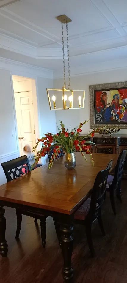 handyman-alpharetta 1 Dining room renovation with new lighting fixture and elegant table setup by Above All Handyman in Alpharetta, showcasing expert craftsmanship and home improvement services."